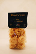 Packaged egg fettuccine from Italfoods on a beige background