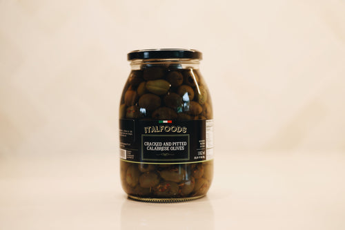 Jar of olives with a label on a beige background